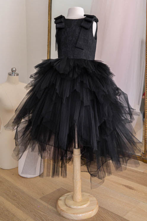 Black tulle flower girl dress with bow shoulder details and full layered skirt displayed on mannequin