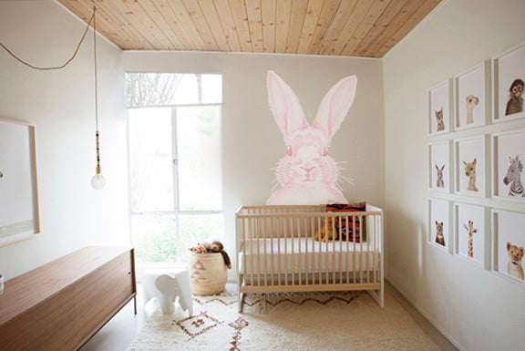 Pink bunny wall decal above white crib in modern baby nursery room