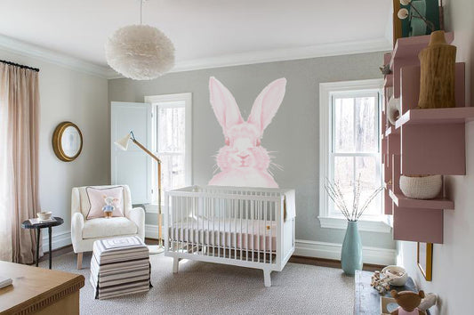 Pink bunny wall decal above white crib in modern baby nursery room
