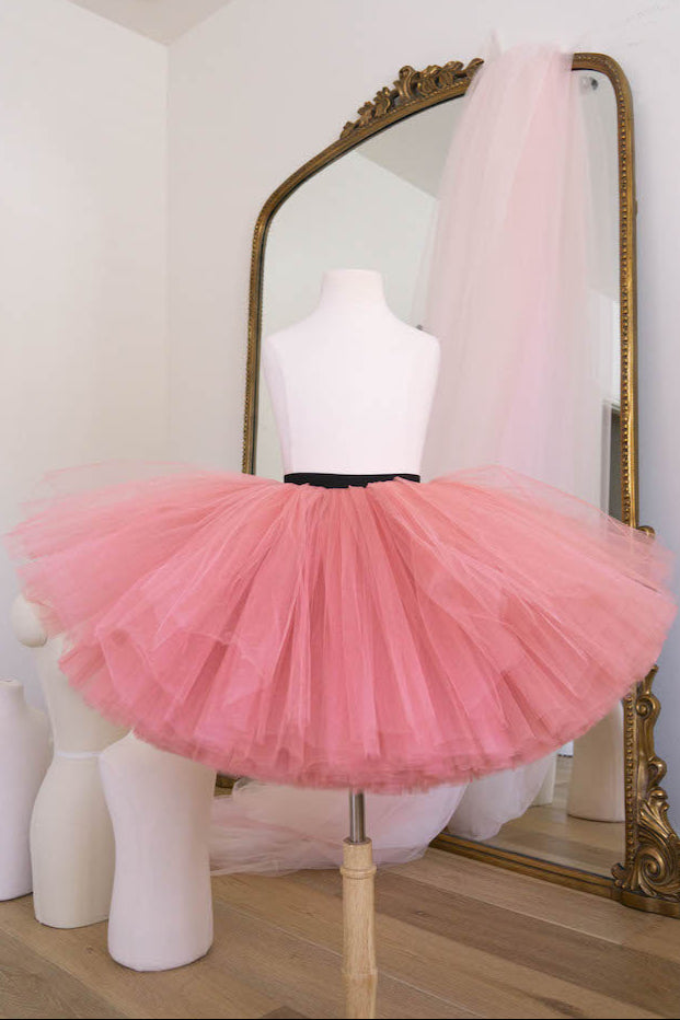 Soft pink tulle tutu skirt with black waistband for girls displayed on mannequin